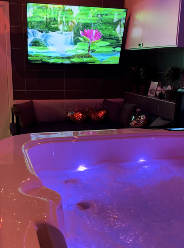 En tv på väggen vid bubbelpoolen